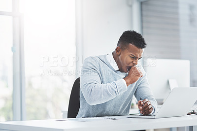 Buy stock photo Shot of a young businessman sitting at his office desk yawning and looking tiresome