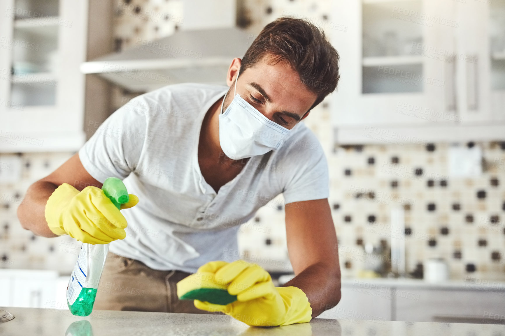 Buy stock photo Cropped shot of a handsome young man cleaning his kitchen at home