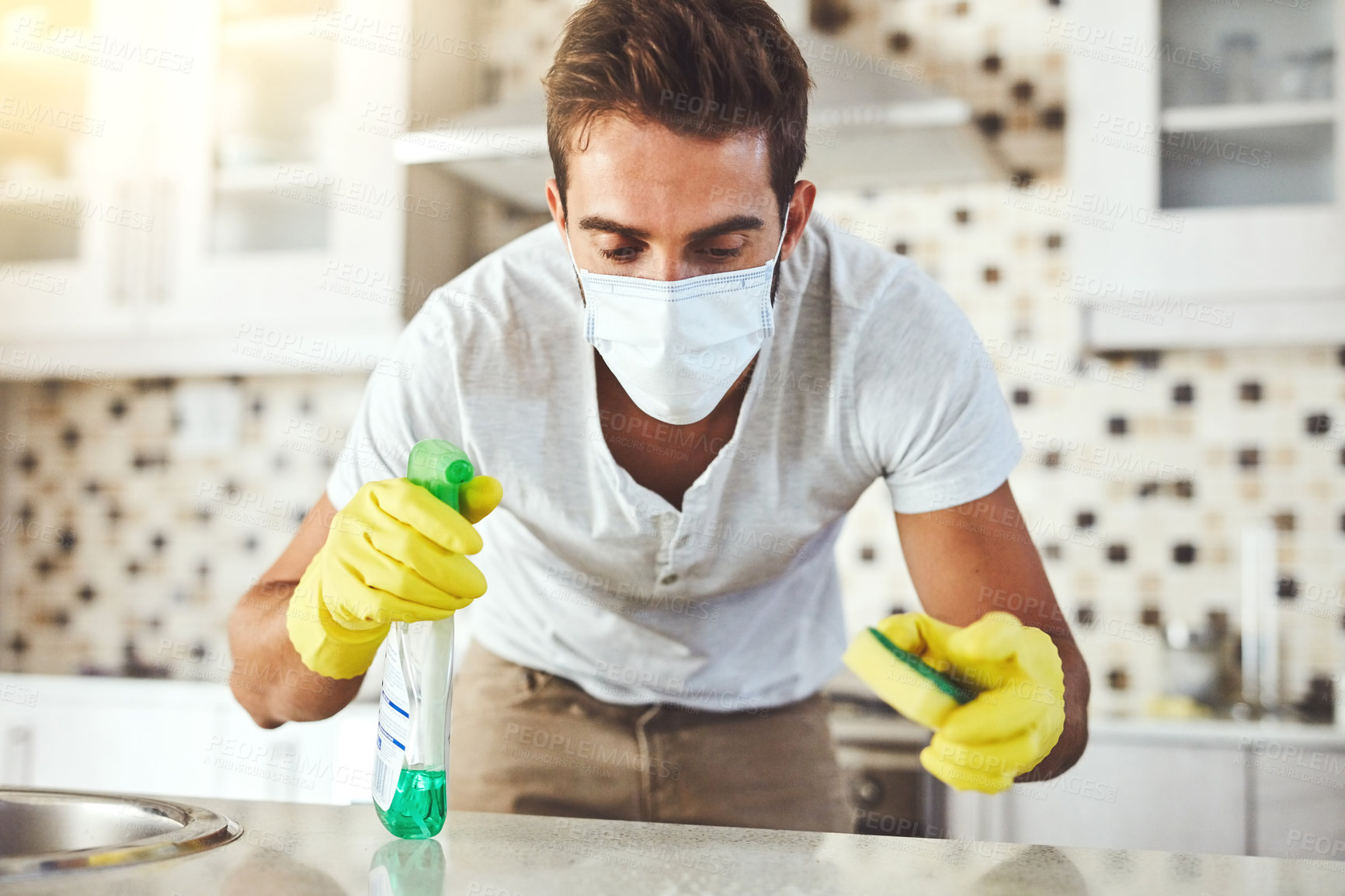 Buy stock photo Man, sponge and spray for cleaning in kitchen, disinfect and chemical for washing counter in home. Male person, face mask and housekeeper service for dust, bacteria and liquid to sanitize for hygiene