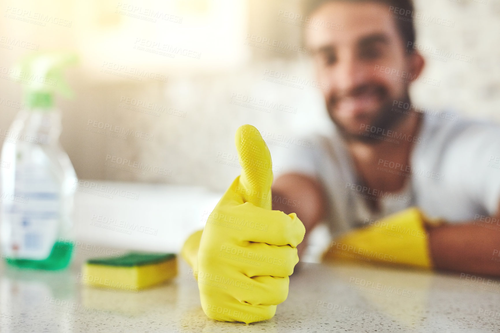 Buy stock photo Kitchen, gloves and man with thumbs up for housekeeping by counter for dirt, bacteria or dust removal. Sponge, detergent and male person with approval hand gesture for cleaning with hygiene in home.