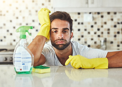 Buy stock photo Cropped portrait of a handsome young man looking down while cleaning his home