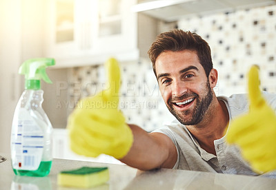 Buy stock photo Cropped portrait of a handsome young man giving you the thumbs up while cleaning his home