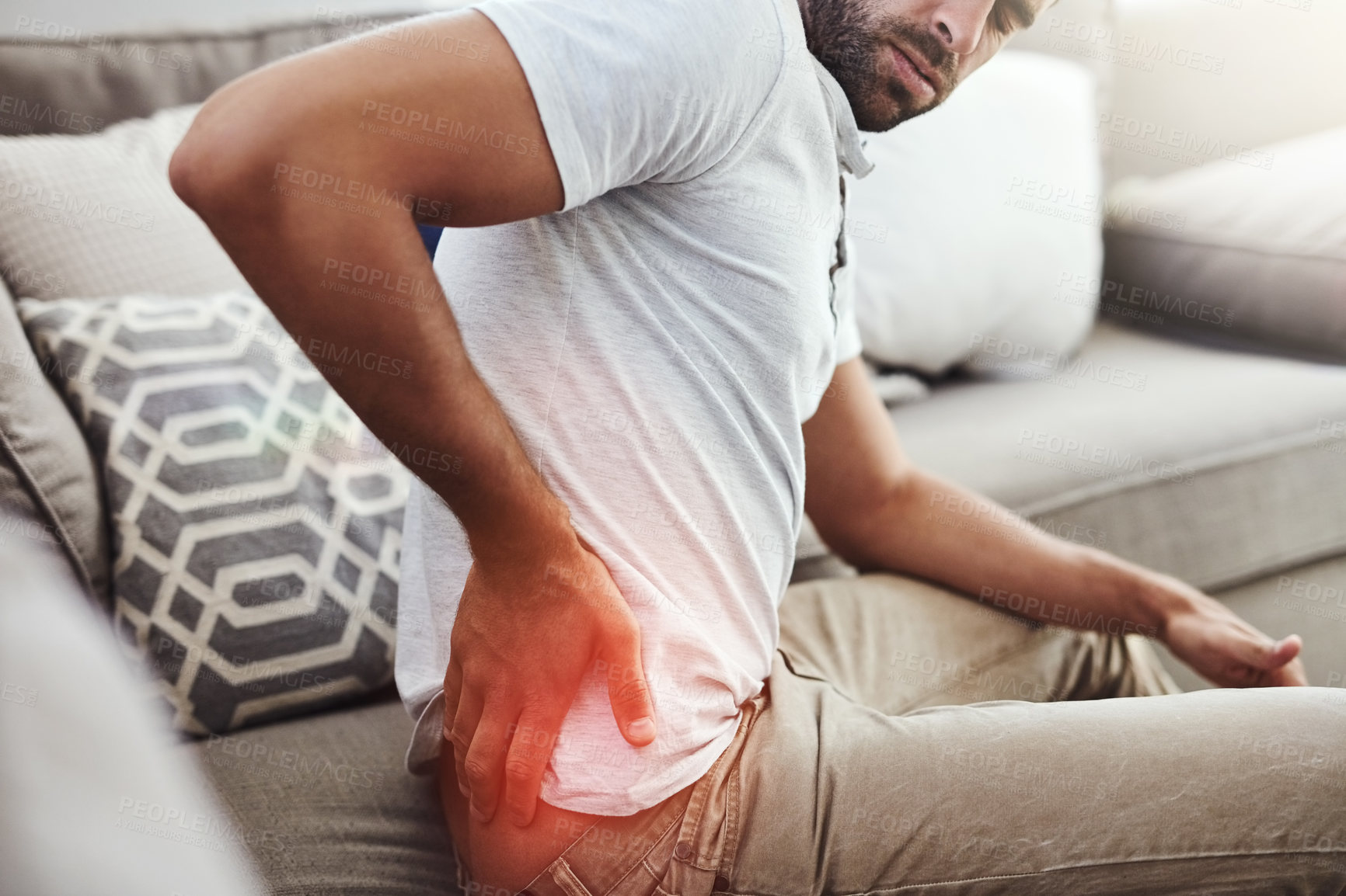 Buy stock photo Back pain, hands and man on sofa with inflammation glow, joint or anatomy risk in his home. Red, backache and male person in a living room with muscle, burnout or spine, bone and emergency in house 