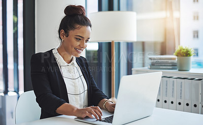 Buy stock photo Shot of a young businesswoman using a laptop in a modern office