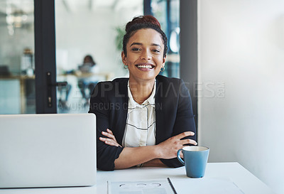 Buy stock photo Shot of a confident young businesswoman working at her desk in a modern office