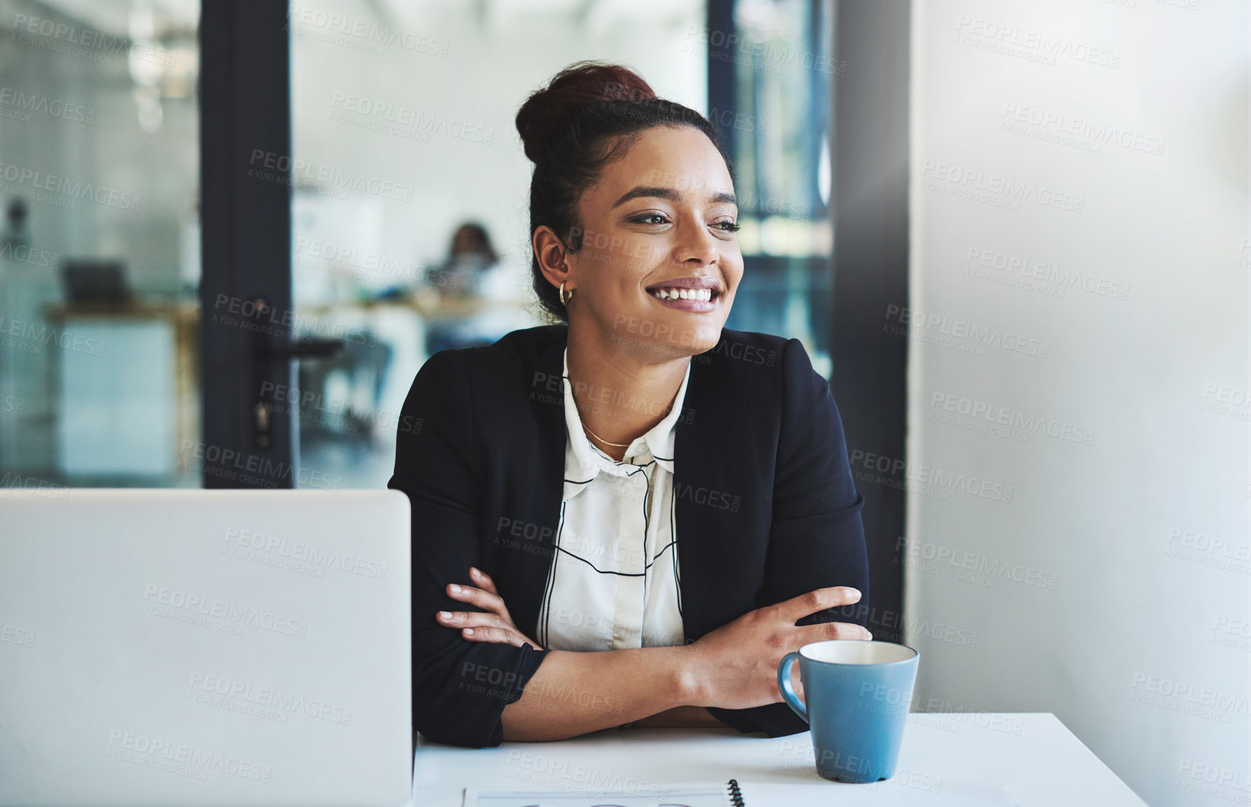 Buy stock photo Shot of a confident young businesswoman working at her desk in a modern office