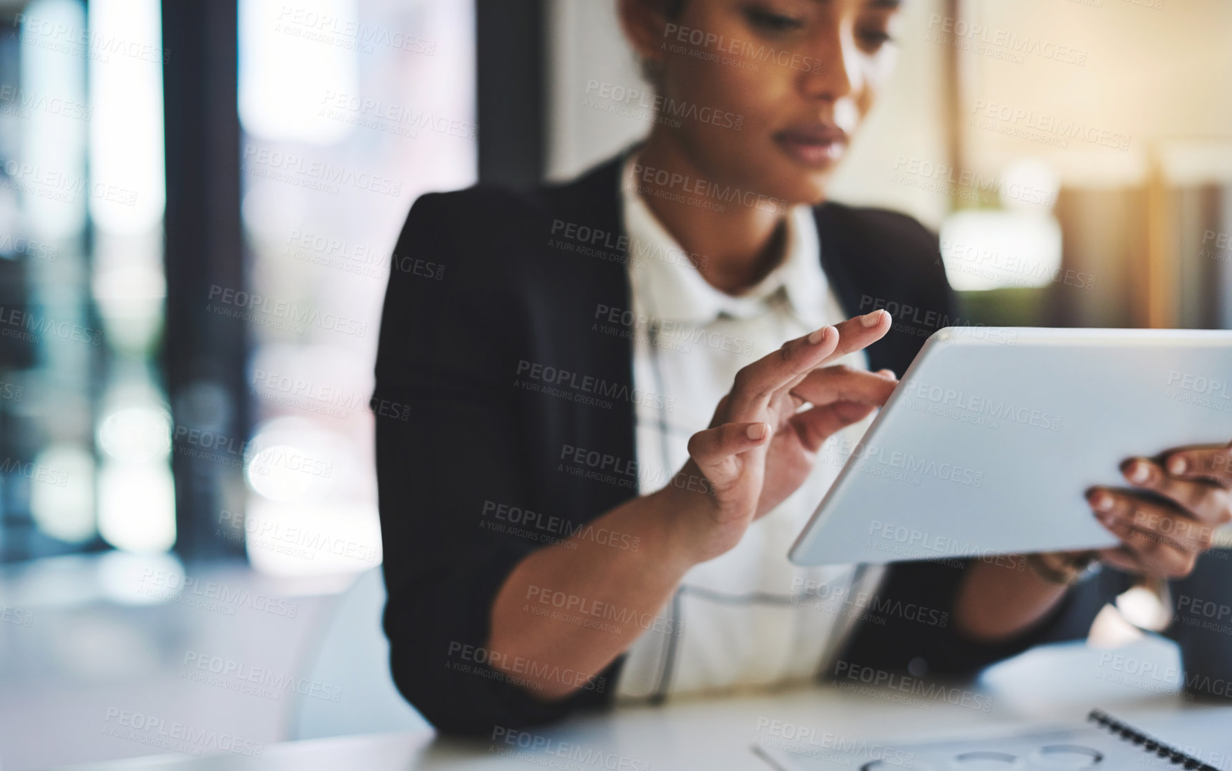 Buy stock photo Cropped shot of a young businesswoman using a digital tablet in a modern office