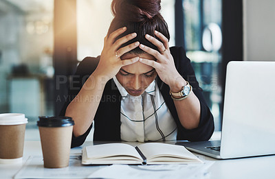 Buy stock photo Shot of a young businesswoman looking stressed while working at her desk in a modern office