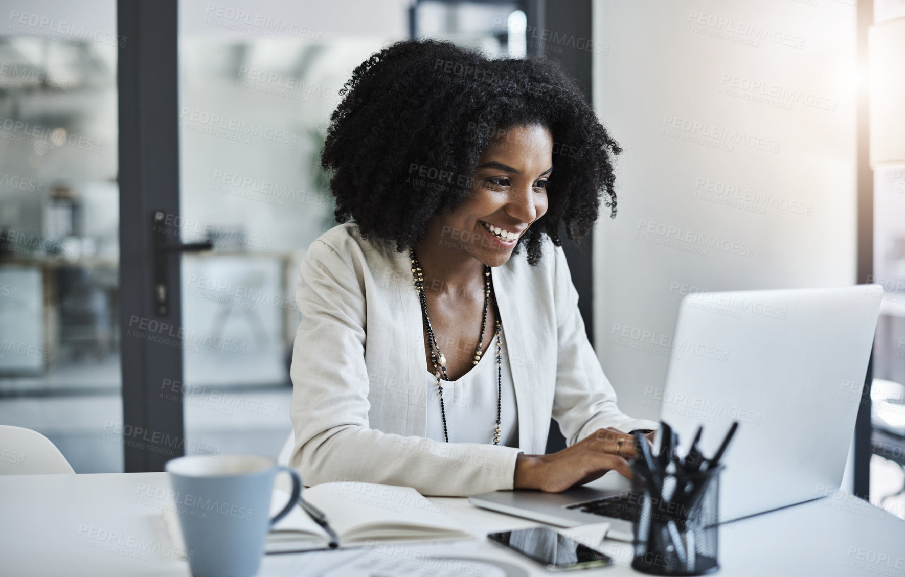 Buy stock photo Shot of a young businesswoman working and in good spirits at her office desk