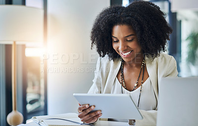 Buy stock photo Shot of a young businesswoman using a digital tablet at her office desk