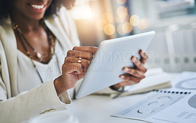 Buy stock photo Shot of an unrecognizable businesswoman using her digital tablet at her office desk