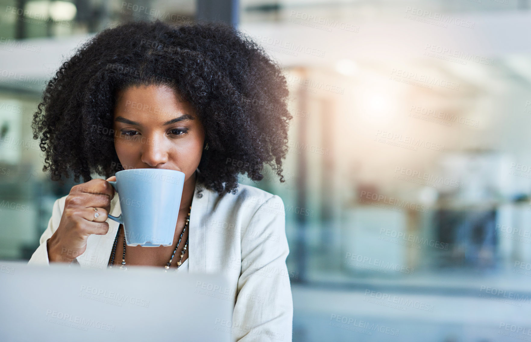 Buy stock photo Shot of a young businesswoman having a cup of coffee while doing some work at her office desk