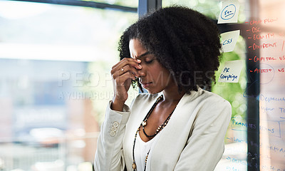 Buy stock photo Shot of a young businesswoman looking stressed out in her office