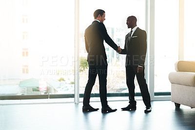 Buy stock photo Full length shot of two businessmen shaking hands in an office