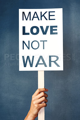 Buy stock photo Studio shot of an woman holding a sign that says “make love not war” against a blue background