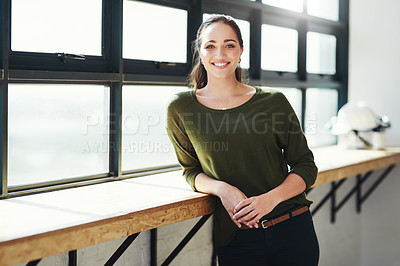 Buy stock photo Cropped portrait of a confident young businesswoman standing at a window in her office