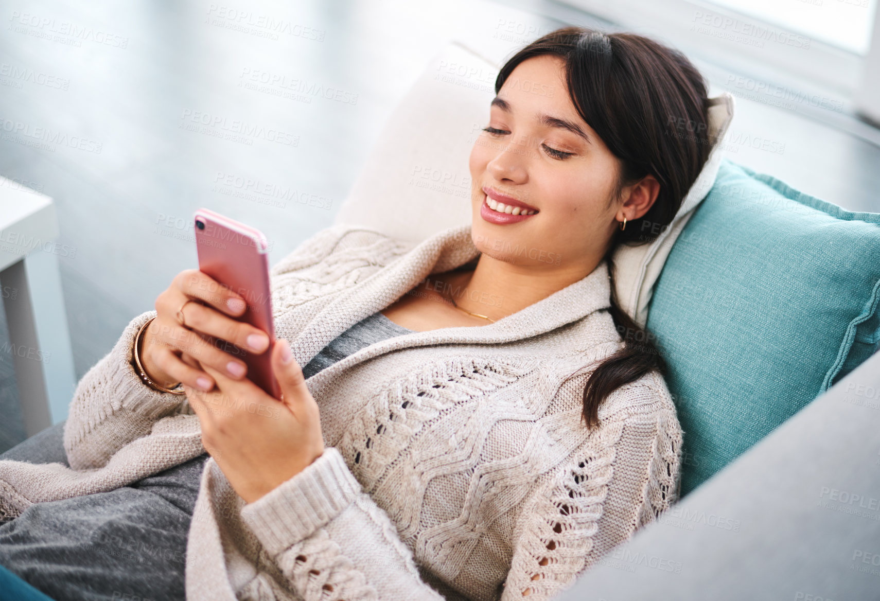 Buy stock photo Asian woman, home and smile on couch with smartphone, text and messages with dating app and social media. Above, female person and online for post, content update and happy with internet videos.