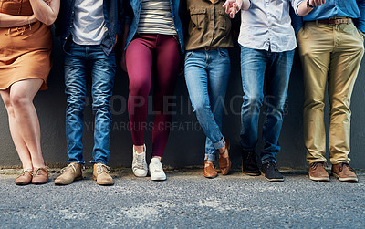 Buy stock photo Closeup shot of a group of unrecognizable people standing in a line against a wall outside
