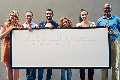 Buy stock photo Portrait of a group of people holding a blank sign against a wall outside