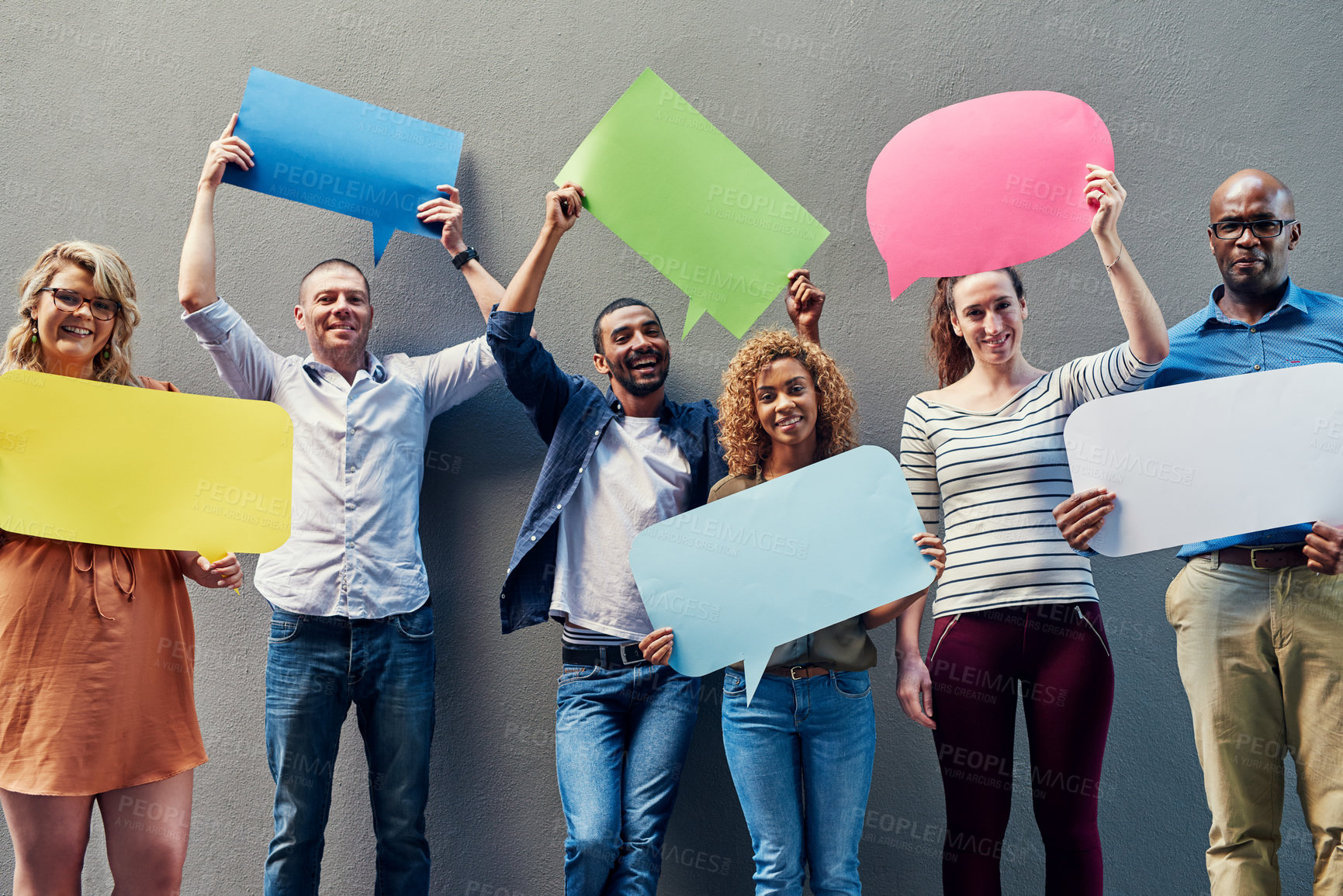 Buy stock photo Portrait of a group of people holding speech bubbles against a wall outside