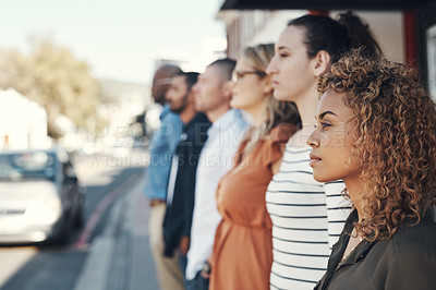 Buy stock photo Shot of a group of people standing in a line in the city