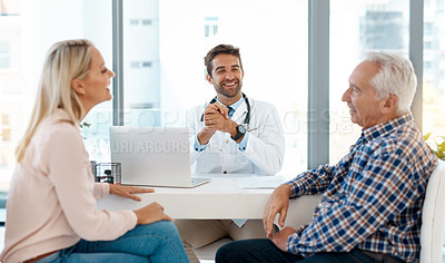 Buy stock photo Cropped shot of a handsome male doctor consulting with a couple in his office