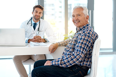 Buy stock photo Cropped portrait of a handsome male doctor consulting with a patient at his desk
