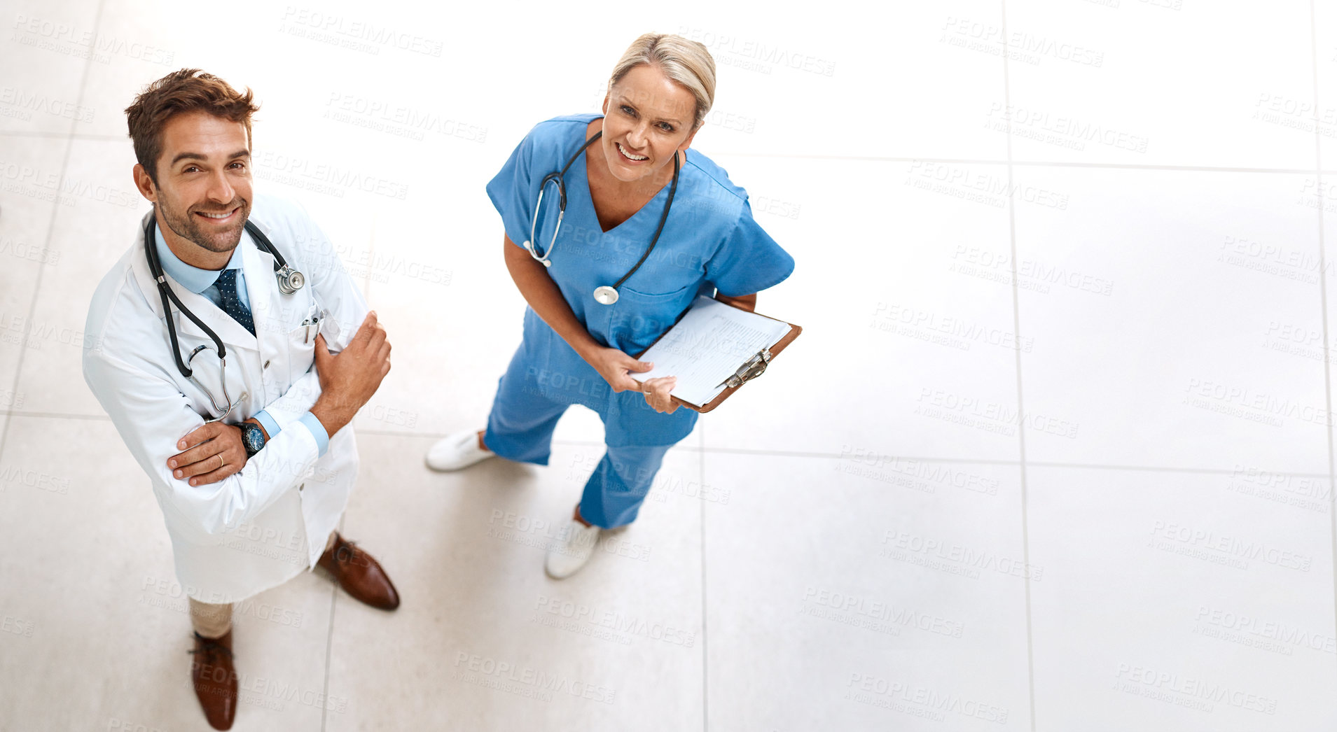 Buy stock photo High angle portrait of two happy healthcare practitioners posing together in a hospital