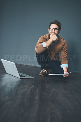 Buy stock photo Studio shot of a young businessman working on a laptop against a grey background