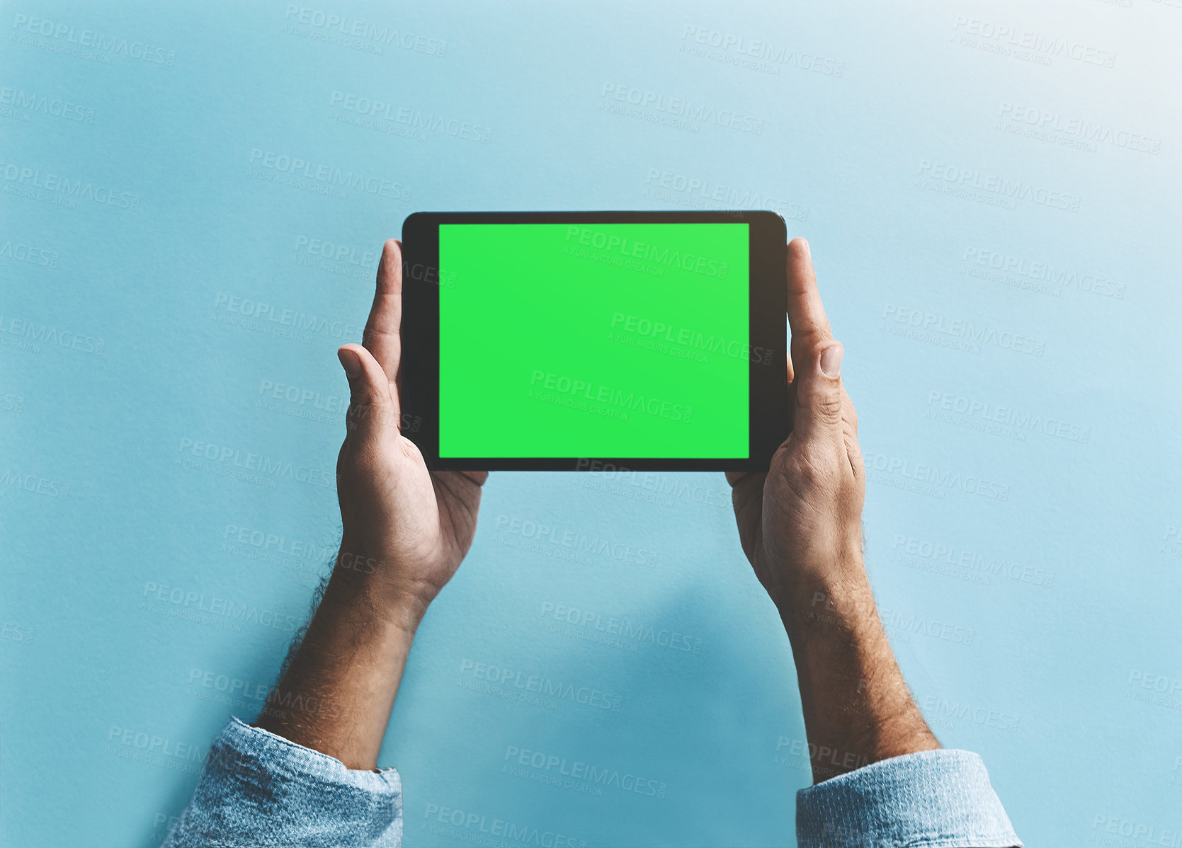 Buy stock photo Studio shot of a man holding a digital tablet with a green screen against a blue background