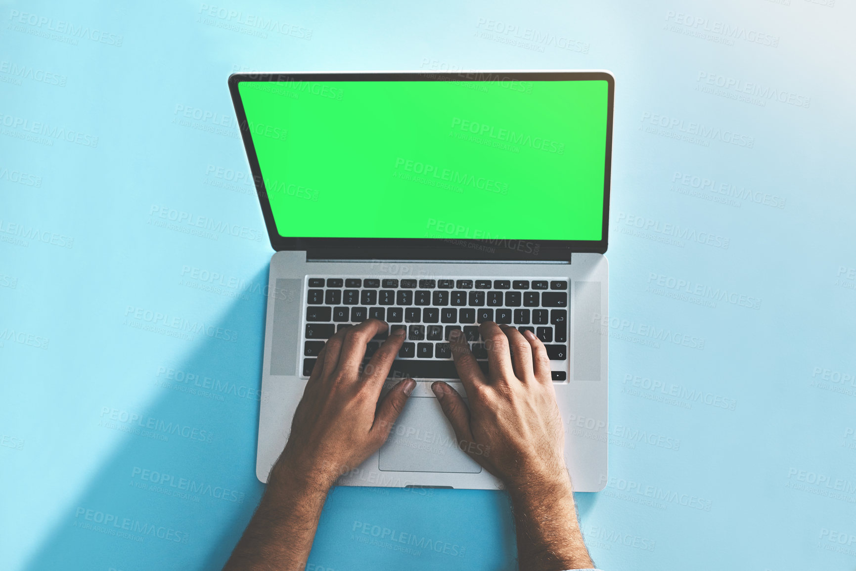 Buy stock photo Green screen, laptop and hands of man in studio top view for social media, email or online communication on blue background. Mockup, keyboard and freelance editor with remote work, editing or project