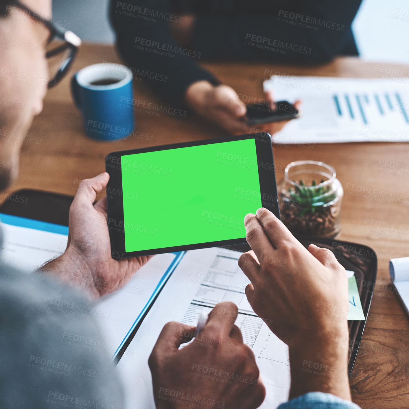 Buy stock photo Green screen, copyspace and chromakey on a tablet screen in the hands of a business man sitting in the boardroom during a meeting. Talking and planning for marketing, advertising and online promotion