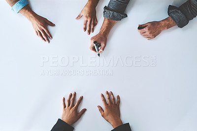 Buy stock photo Business people writing on white paper in meeting, planning a marketing strategy and writing creative ideas together from above. Top view of hands of team of designers drawing a design on blank page