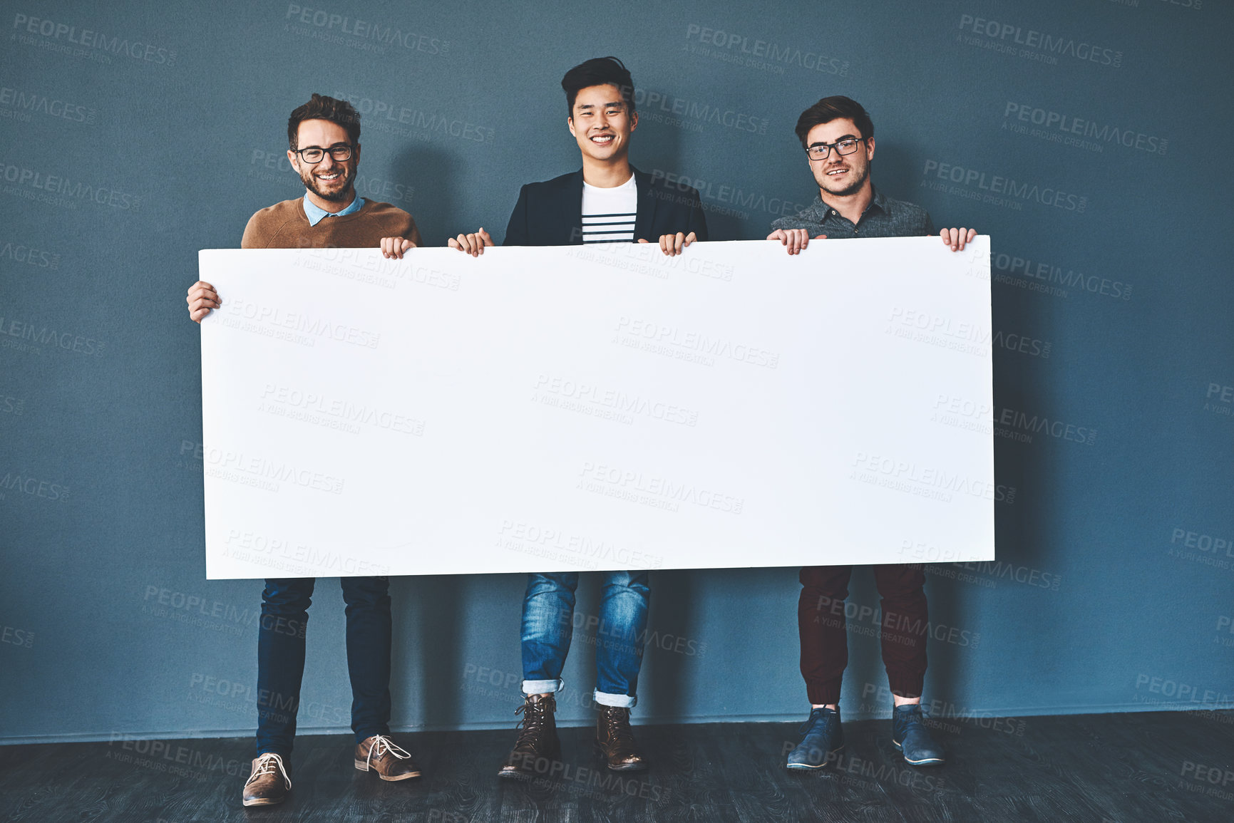 Buy stock photo Studio shot of businesspeople holding up a blank sign against a grey background