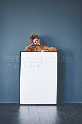 Buy stock photo Studio shot of a young woman posing with a blank sign against a grey background