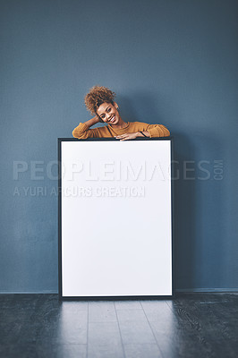 Buy stock photo Blank white poster with copyspace with a young smiling woman holding the sign. Happy female relaxing by a board looking carefree about marketing content. Positive lady standing behind an empty banner