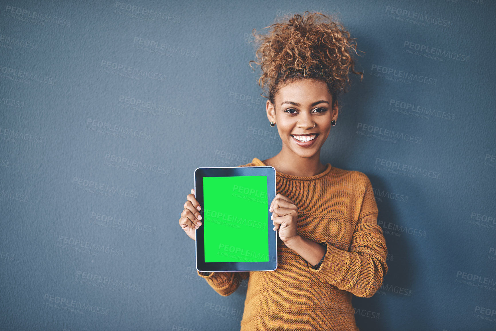 Buy stock photo African female holding green screen tablet copyspace. Cute, attractive and smiling young afro woman standing and showing a mobile device.Happy, cheerful and ethnic woman after buying new app. 
