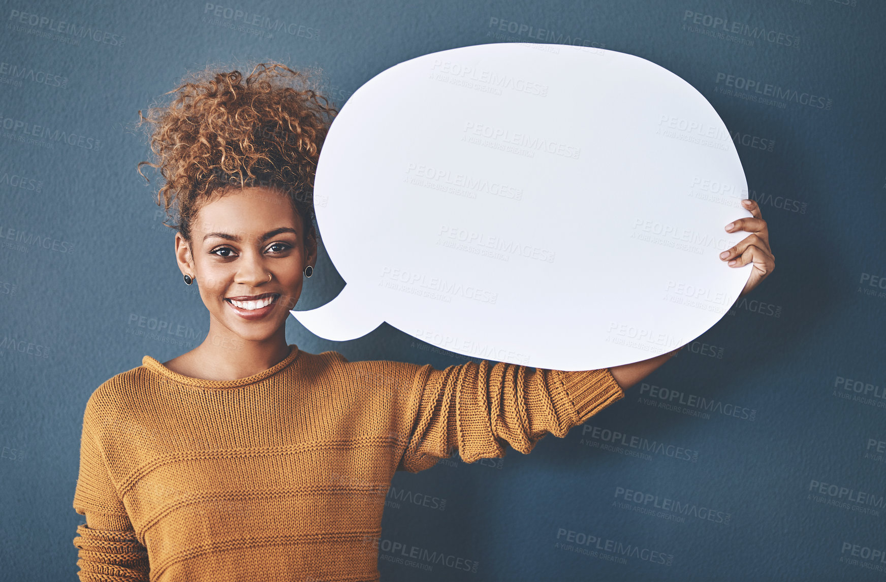 Buy stock photo Studio shot of a young woman holding a speech bubble against a grey background