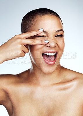 Buy stock photo Studio shot of a beautiful young woman posing with the peace sign over her eye