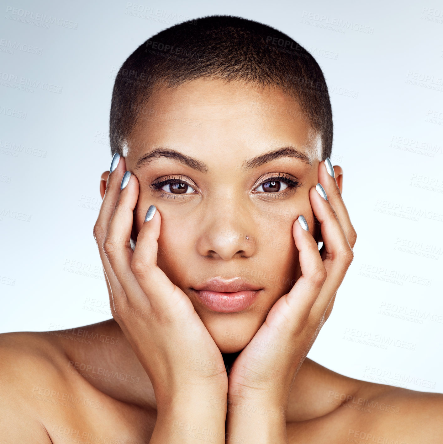 Buy stock photo Shot of a beautiful young woman touching her face against a grey background