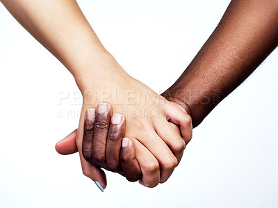 Buy stock photo Studio shot of two unrecognizable people holding hands against a grey background