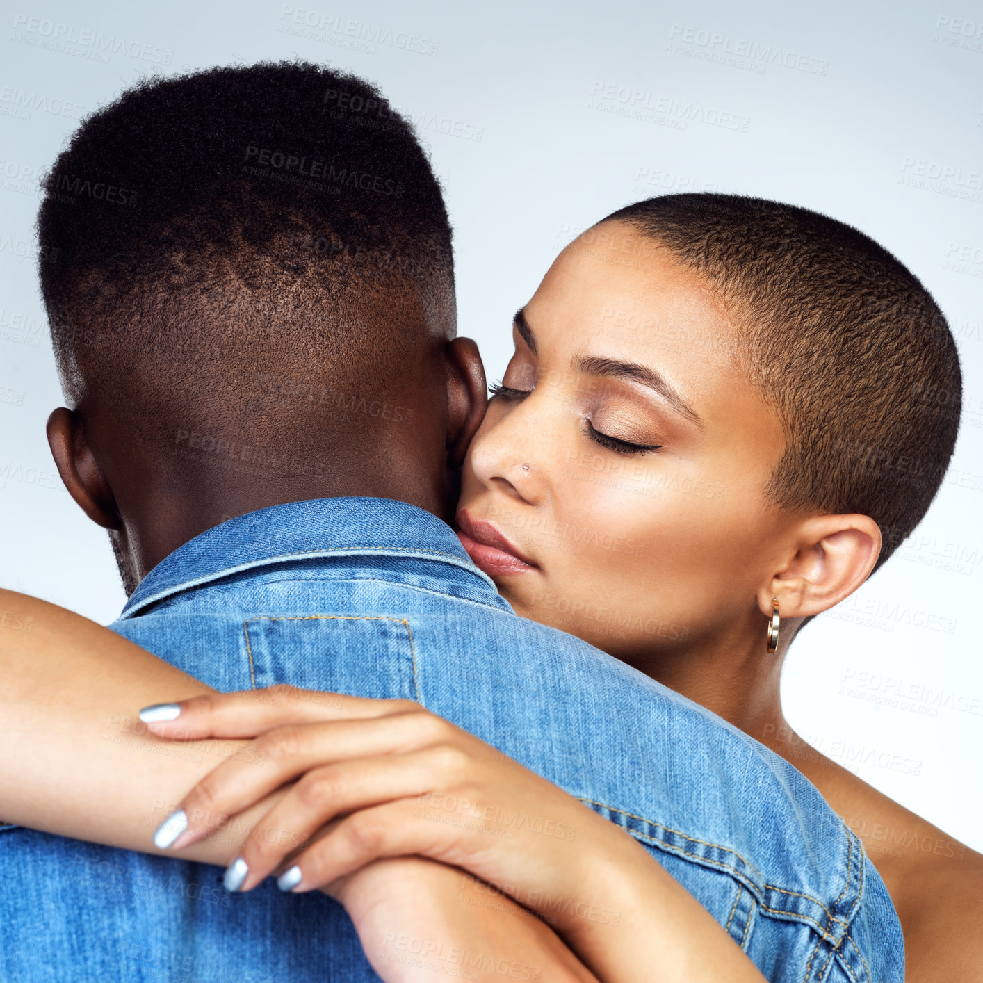 Buy stock photo Studio shot of a  young couple embracing each other against a grey background