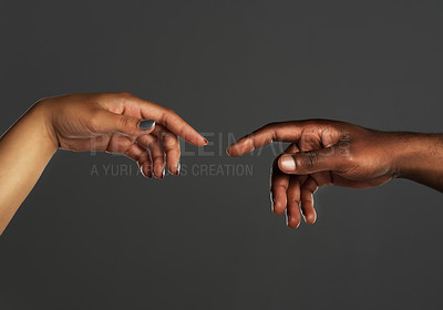 Buy stock photo Studio shot of two unrecognizable people reaching out their hands towards each other against a grey background