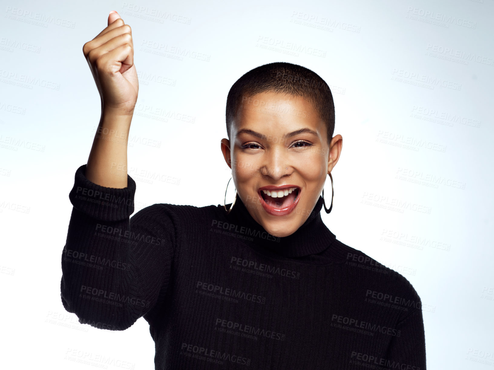 Buy stock photo Studio shot of an attractive young woman posing with her arm raised and fist clinched against a grey background