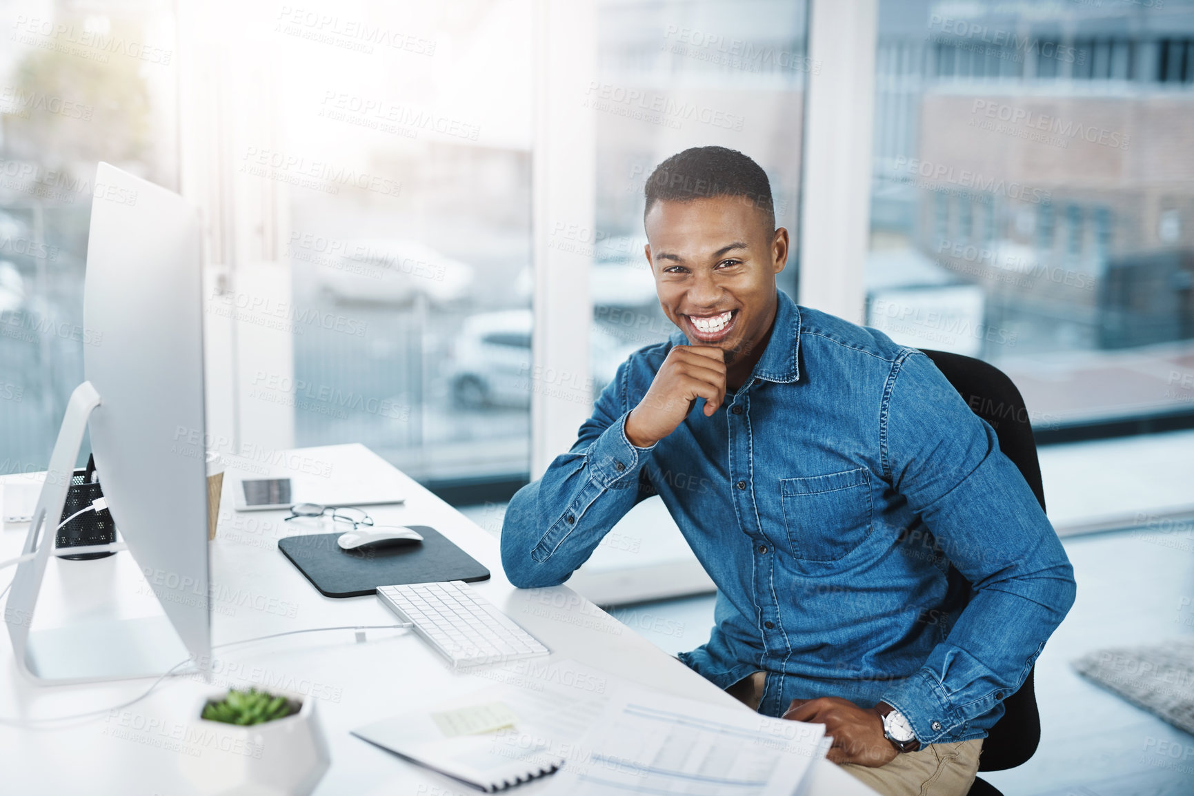 Buy stock photo Portrait of a young businessman posing and in good spirits at his office desk