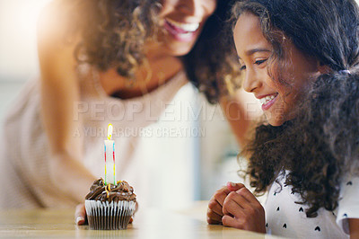 Buy stock photo Birthday, cupcake and mother with child in home at table for wish, candle and surprise for celebration. Family, food and happy mom with excited young girl with cake, dessert and sweet treat for party