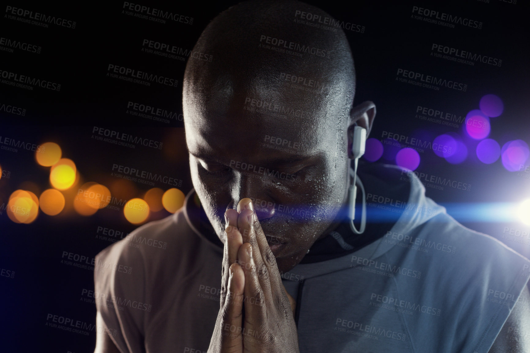 Buy stock photo Black man, athlete and praying hands for sports exercise at night with bokeh for competition, hope or dark background. Male person, earphones and workout training for marathon run, belief or fitness