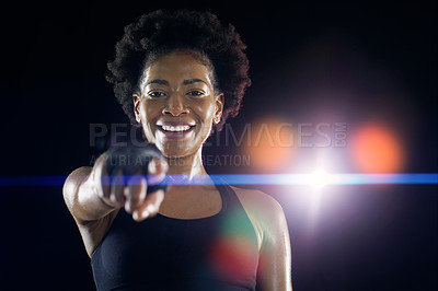 Buy stock photo Studio shot of a young sportswoman posing with her finger pointed to the camera against a dark background