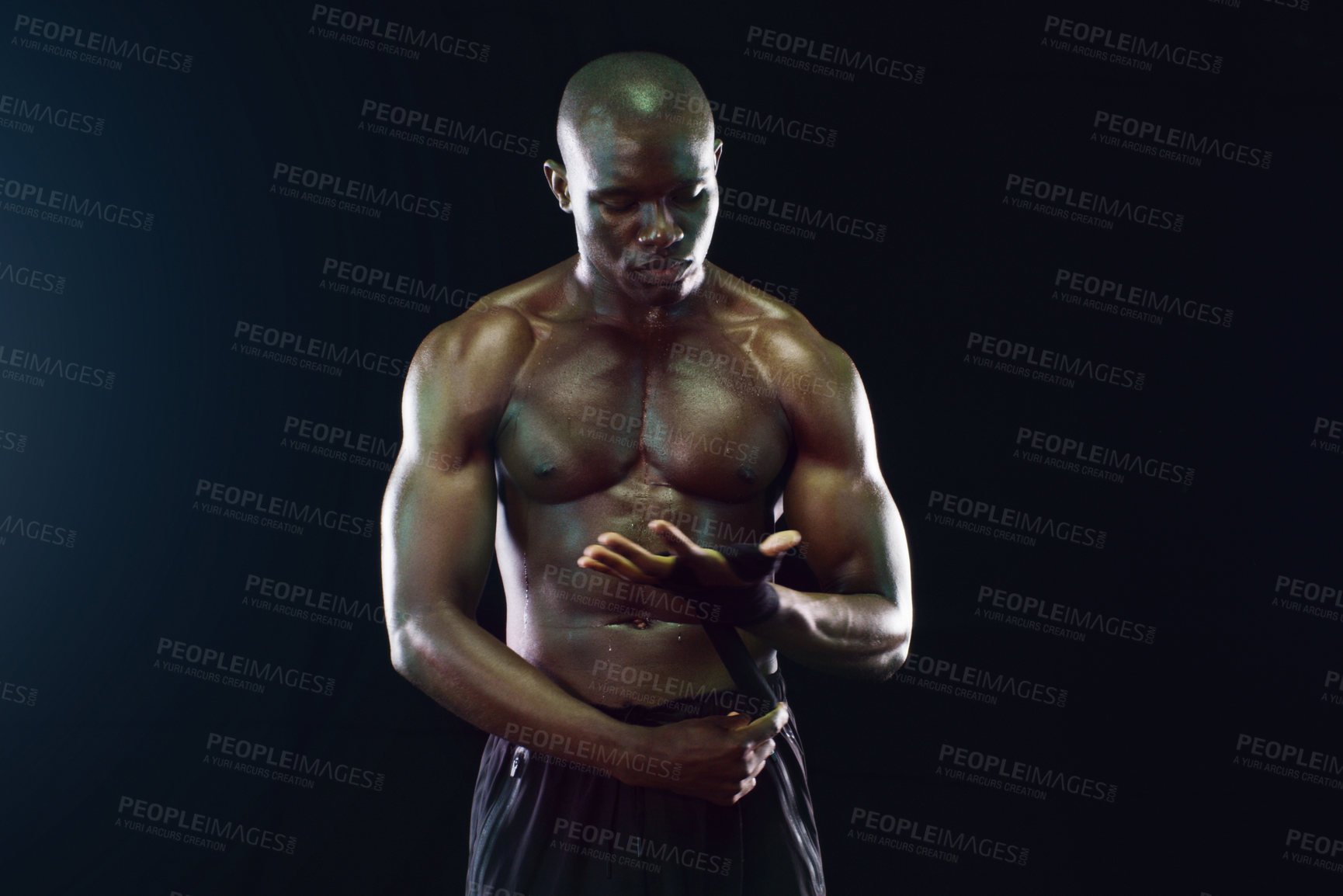 Buy stock photo Studio shot of a shirtless young sportsman posing against a dark background