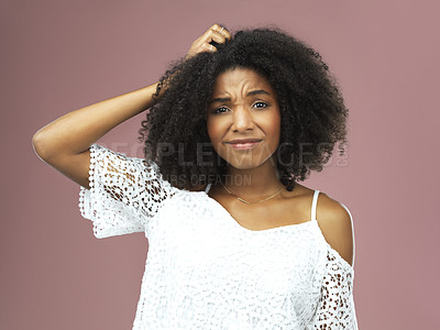 Buy stock photo Shot of a beautiful young woman looking confused against a pink background